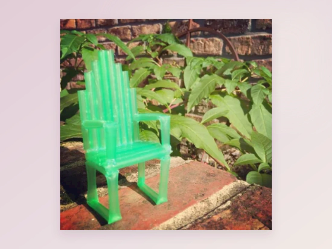 A miniature green chair made from drinking straws
