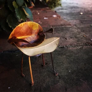 A miniature chair made from autumn leaves and thin legs