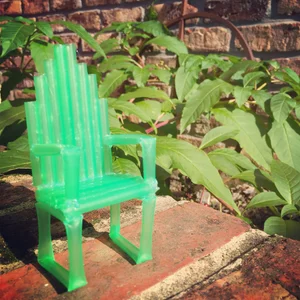 A miniature green chair made from drinking straws